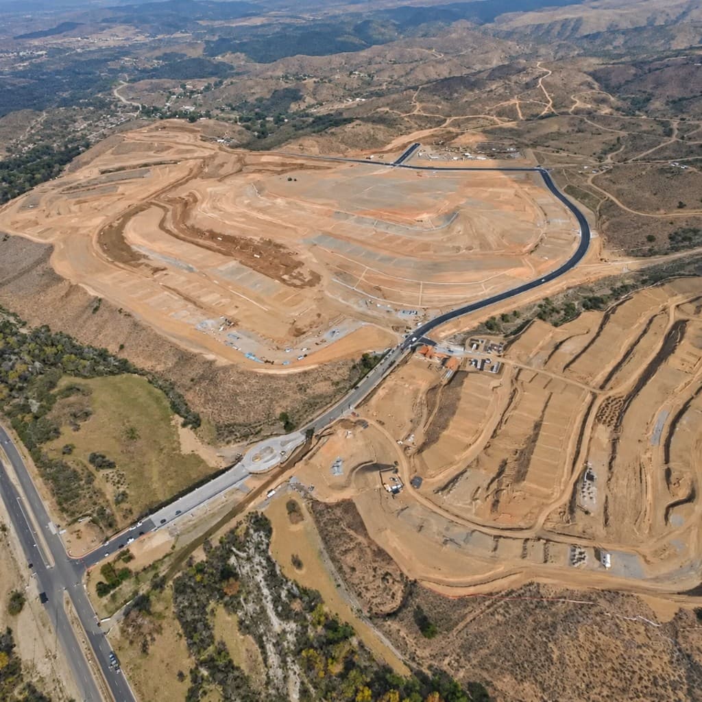 Aerial view of graded residential lots, new roads, and a hillside development site
